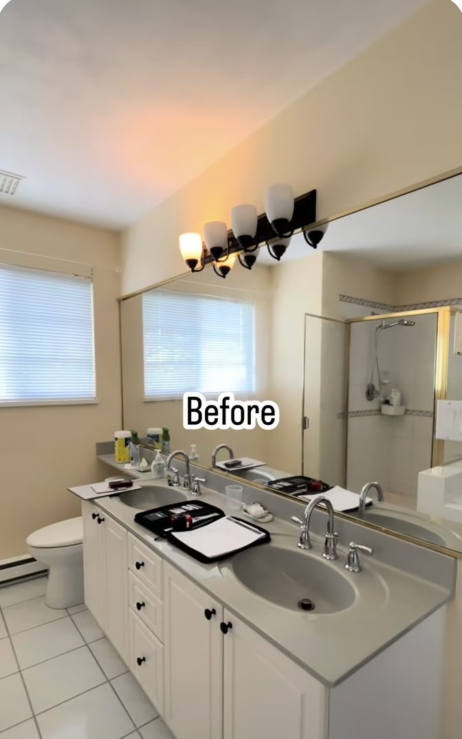 Coquitlam bathroom before: dated double vanity, brass fixtures and a large plain mirror
