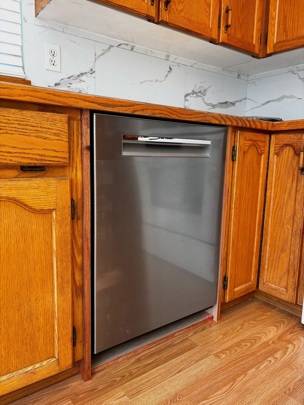 New stainless dishwasher fitted into oak kitchen cabinets in Maple Ridge
